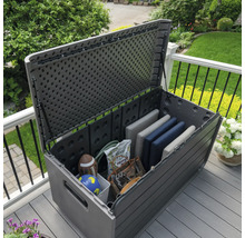 Geöffnete graue Gartenbox auf einer Terrasse mit Gartenwerkzeug und Kissen