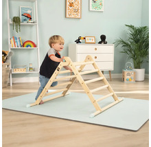 Enfant grimpant sur une structure d''escalade d''intérieur en bois sur un tapis de jeu dans une chambre d''enfant.