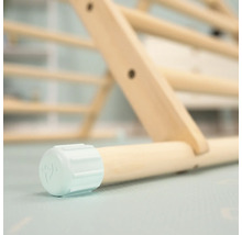 Gros plan sur un triangle d''escalade en bois avec un pied de couleur claire