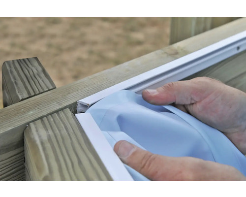 Une personne installe un couvercle sur une structure en bois.