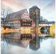 Ansicht des historischen Heilig-Geist-Spitals mit Turm in Nürnberg, Deutschland, mit Reflexionen im Fluss