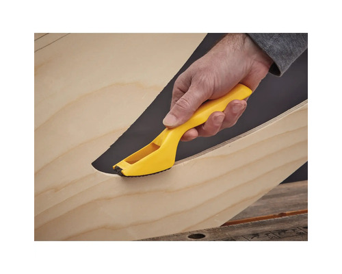 Hand mit gelbem Entgratungswerkzeug an Holzkante