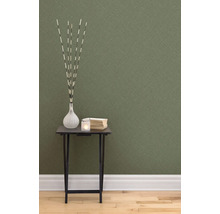 Dekorative Szene mit Tisch, Vase, Kerze und Büchern vor einer strukturierten Tapete