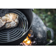 Fleischstück auf Grillrost über offener Feuerstelle