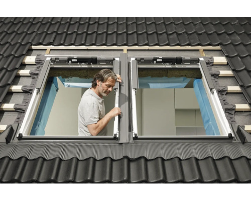 Dachdecker montiert Dachfenster im Ziegeldach.