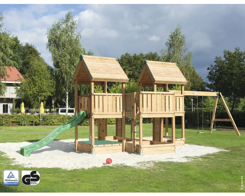 Cabane de jeu sur pilotis P7S pin Douglas HY-Land 1140 x 440 cm bois tour, bac à sable, 2 balançoires, bâche, pierres d'escalade, mur d'escalade, toboggan Tour de jeux avec toboggan, balançoire et bac à sable sur une pelouse.