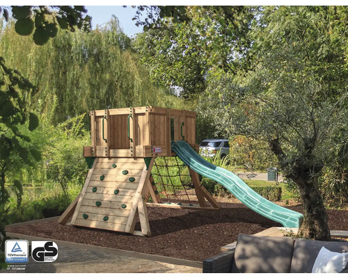 Aire de jeux avec mur d''escalade, tour, filet et toboggan dans le jardin