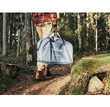 Personne portant des toilettes de camping bleues dans un sac dans la forêt