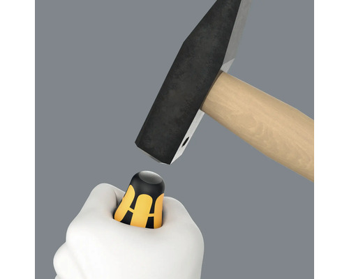 La main tient un protège-pouce sous le marteau