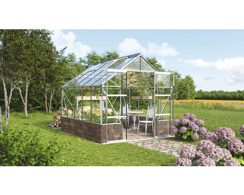 Serre avec étagères à plantes et coin salon dans le jardin