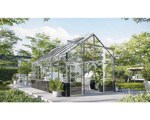 Serre avec parois en verre et cadre en métal dans le jardin.