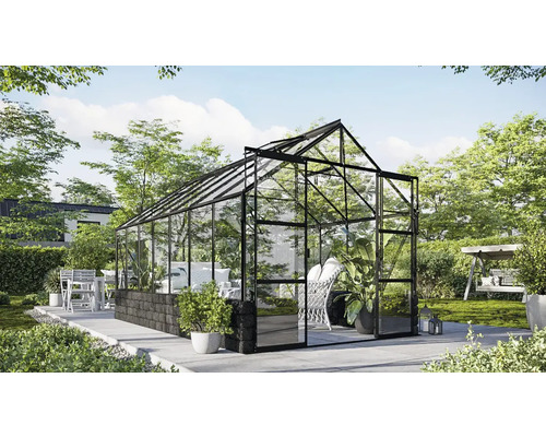 Serre avec cadre en acier et panneaux de verre dans le jardin