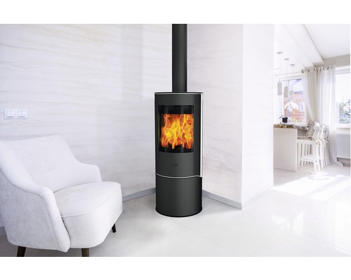 Moderner Wohnraum mit schwarzem Kaminofen, weißem Sessel und hellem Interieur