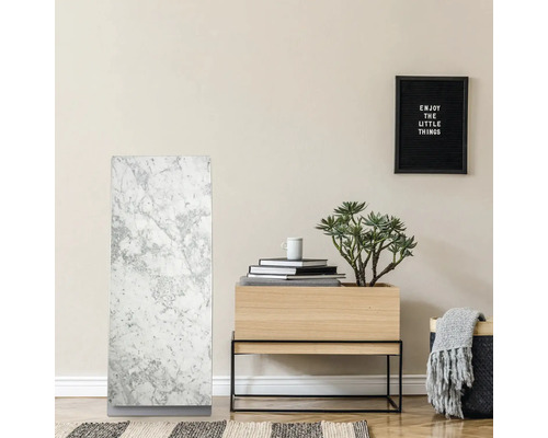 Intérieur avec radiateur en marbre, table en bois avec plante et décoration et une inscription encadrée
