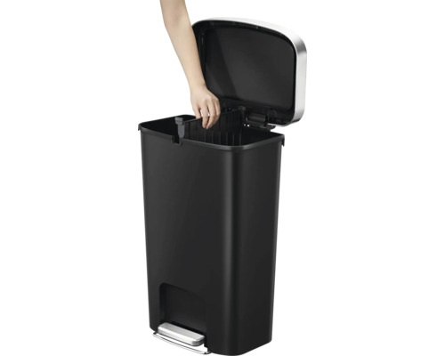 Poubelle à pédale noire avec couvercle ouvert et main