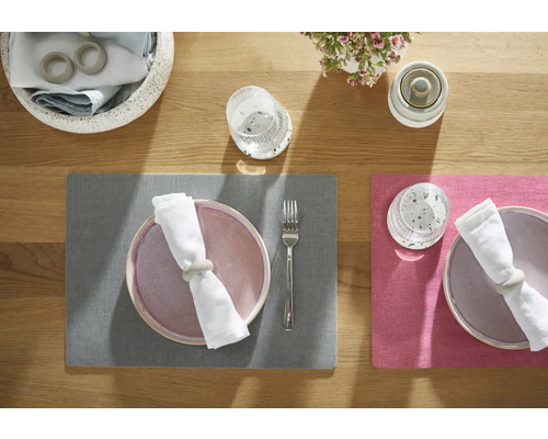 Décoration de table avec sets de table, assiettes, serviettes de table, ronds de serviette, verres, couverts et décorations florales sur une table en bois