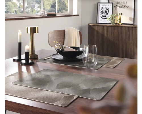 Table à manger avec sets de table, vaisselle et décoration dans une salle à manger