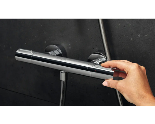 Gros plan d''une main actionnant un mitigeur thermostatique de douche Hansgrohe