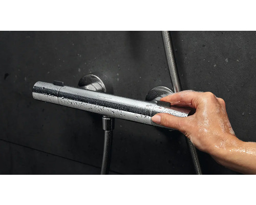 Image d''une main actionnant un thermostat de douche