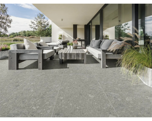 Terrasse mit grauen Terrassenplatten und Gartenmöbeln