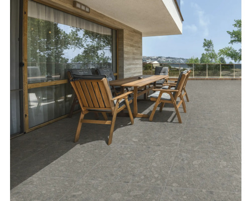 Terrasse mit Holztisch, Stühlen und grauen Bodenfliesen.