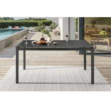 Table de jardin avec vaisselle et boissons sur une terrasse près d''une piscine