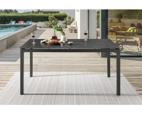 Table de jardin avec vaisselle et boissons sur une terrasse près d''une piscine