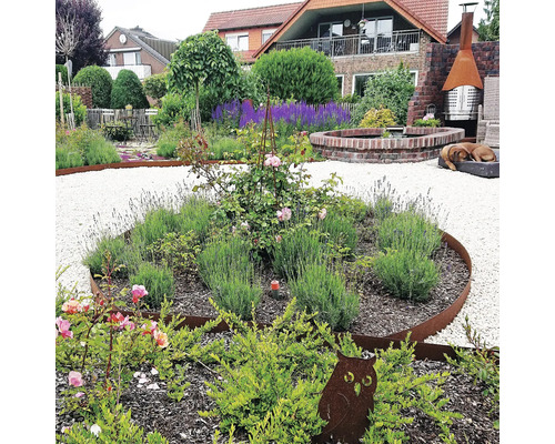 Gestalteter Garten mit Kieswegen, Blumenbeeten mit Rosen und Lavendel, Gartendekoration und Ziegelbrunnen