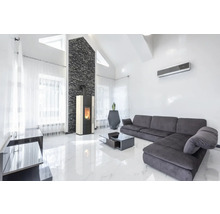 Helles Wohnzimmer mit Kaminofen, Sofa und Klimaanlage