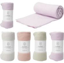 Couvertures en polaire de différentes couleurs, 130 x 160 cm, roulées et empilées.