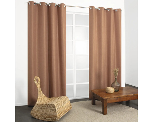 Salon avec rideaux, table et fauteuil en osier