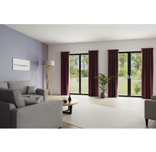 Salon avec canapé, lampadaire, table basse, plante d''intérieur et rideaux devant les fenêtres.