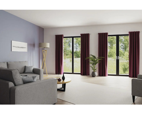 Salon avec canapé, lampadaire, table basse, plante d''intérieur et rideaux devant les fenêtres.