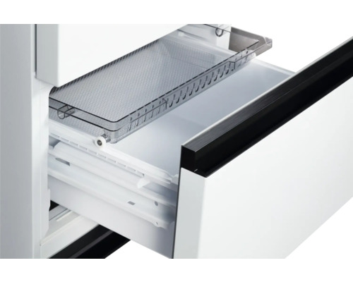 Geöffnete Schublade eines Kühlschranks mit transparenter Ablage