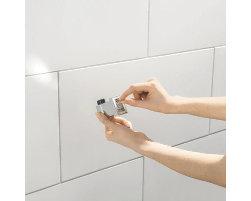 Installation d''un butoir de porte magnétique sur un mur carrelé.