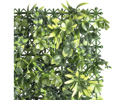 Tapis de plantes artificielles avec différentes feuilles et une grille à l''arrière.