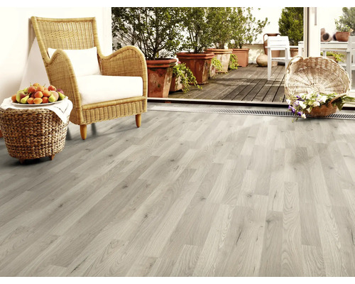 Plancher en bois clair dans un salon avec fauteuil en osier et décoration