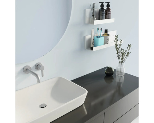 Modernes Badezimmer mit Waschbecken, Spiegel und Wandregalen zur Aufbewahrung von Badartikeln.