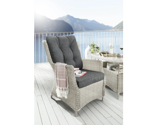 Geflochtener Sessel mit Polsterauflage auf einer Terrasse mit Seeblick