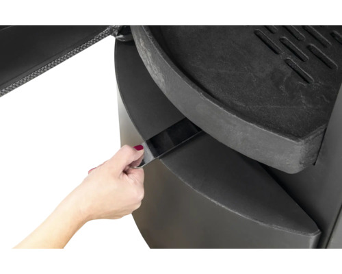 Vue détaillée d''un poêle à bois avec cendrier en cours d''utilisation