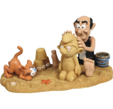 Comicfigur Gargamel mit Gargamelino am Strand mit Katze Azrael und Sandburg