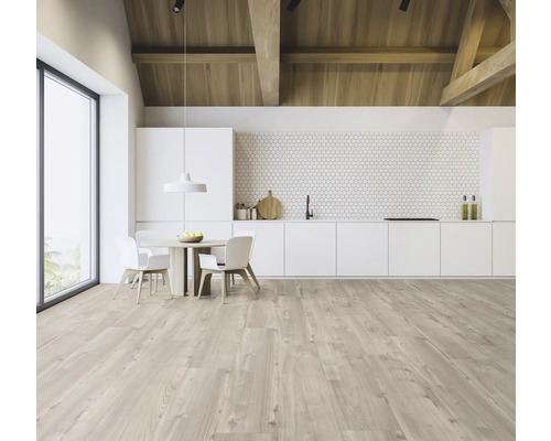 Coin cuisine clair et spacieux avec plafond à poutres en bois, table à manger et kitchenette