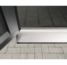 Vue détaillée d''un seuil de porte en aluminium sur des pavés