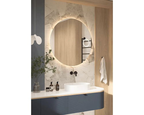 Salle de bain moderne avec miroir rond, lavabo et meuble bas en bleu