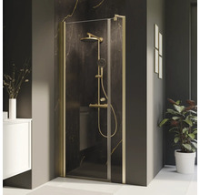 Cabine de douche avec robinetterie dorée dans une salle de bain moderne