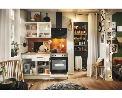 Cuisine lumineuse avec armoires de cuisine, cuisinière, hotte aspirante et étagères dans une pièce avec décorations.