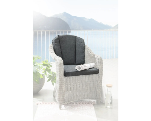 Fauteuil tressé avec coussins gris sur une terrasse avec vue sur le lac
