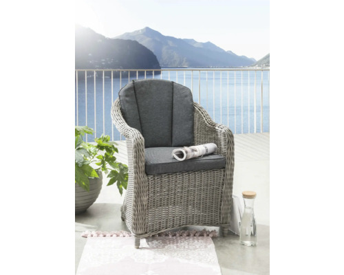 Fauteuil tressé avec coussins gris sur balcon avec vue