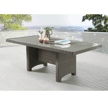 Table de jardin en rotin avec plateau en verre sur une terrasse
