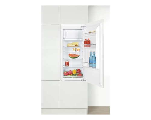 Réfrigérateur intégré avec des aliments comme du fromage, des boissons et des légumes